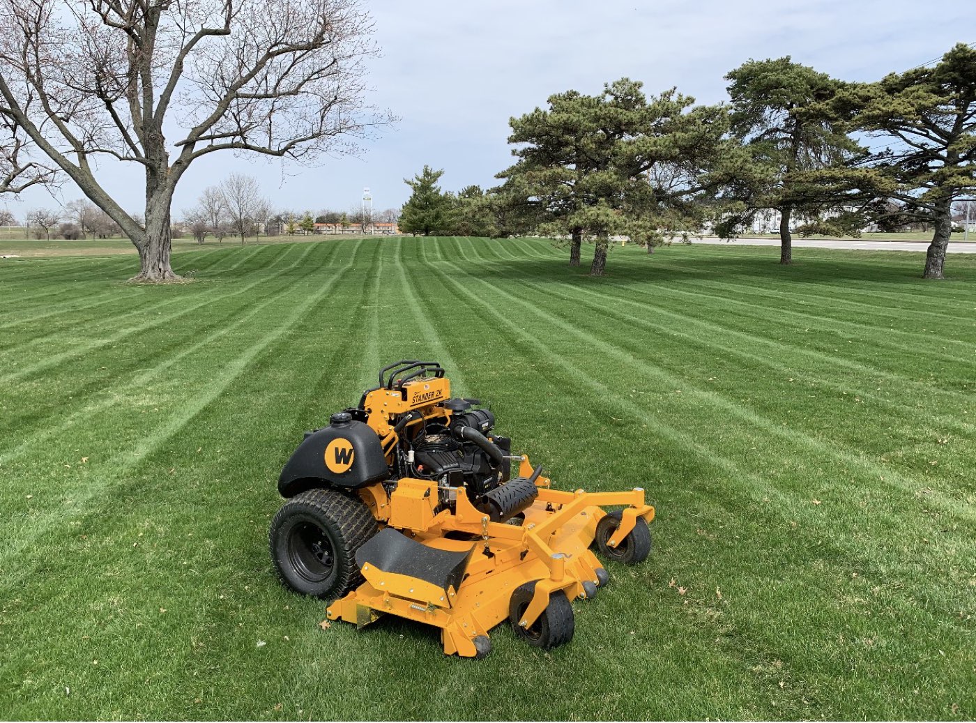 Greener Results stand-on mower on a freshly striped lawn